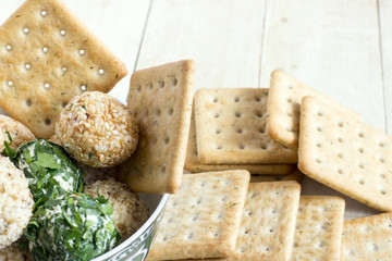 Cheeseballs with crackers on light wood background