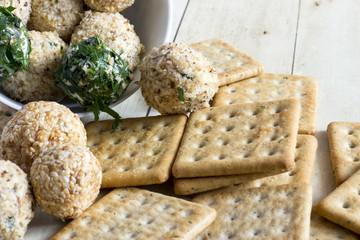 Cheeseballs with crackers on light wood background
