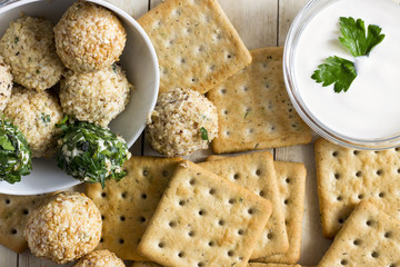 Cheeseballs with crackers on light wood background