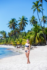 young pretty sexy girl in bikini posing on a tropical beach