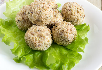 Cheeseballs in white plate on light wood background