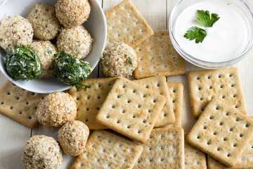 Cheeseballs with crackers on light wood background