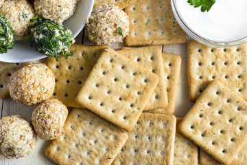 Cheeseballs with crackers on light wood background
