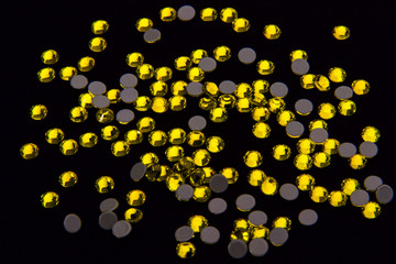 Yellow Rhinestones on Black Fabric Background.