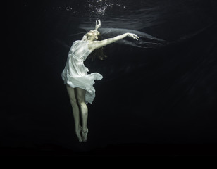 Young female ballet dancer dancing underwater