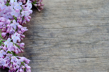 Fototapeta na wymiar Violet lilac flowers on rustic table background