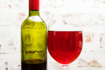 Bottle of red wine with glass ready to pour