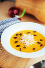 Pumpkin soup in white bowl, dietary vegetable