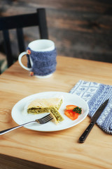 pie with spinach and tomato slice on wooden table.