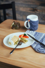 pie with spinach and tomato slice on wooden table.