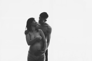 Pregnant woman and her husband on white background