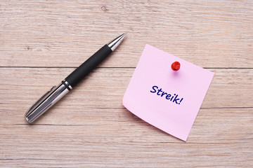 Wort Streik auf rosa Haftnotiz mit rotem Pin