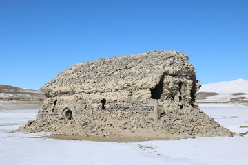 Ruins of an old church in the middle of the Tolors reservoir, Armenia, in a sunny winter day. In sumner the whole church is covered with water. It can be seen and reached only in winter