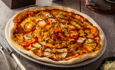 Spicy chicken pizza with tomato, cheese, chicken, bell pepper, caramelized onions and barbecue sauce.