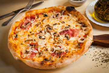 Pizza with tomato, cheese, parma ham, onions and mushrooms