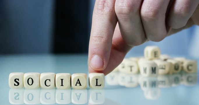 Slow motion macro of the word "Social" made of the wooden letter blocks . Concept of financial market and future of stock market business.