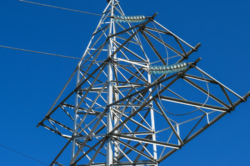 Supports high-voltage power lines against the blue sky