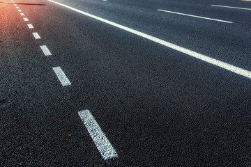 Asphalt road along the sea at sunset