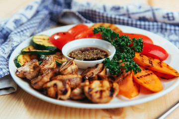 grilled vegetables with sauce on a wooden background