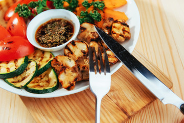 grilled vegetables with sauce on a wooden background