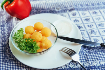 Deep fried cheese balls with lettuce and sauce