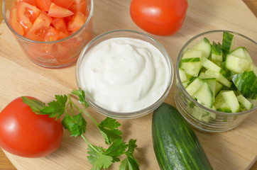 Salad with cucumbers, tomatoes and sour cream, mayonnaise.