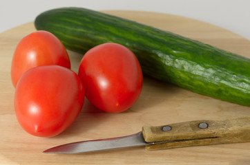 Tomatoes and cucumbers on the cutting board.
