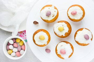 Easter birds nest cupcakes with chocolate candy eggs , whipped cream and cotton candy