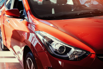 Obraz na płótnie Canvas Headlights and hood of sport red car.