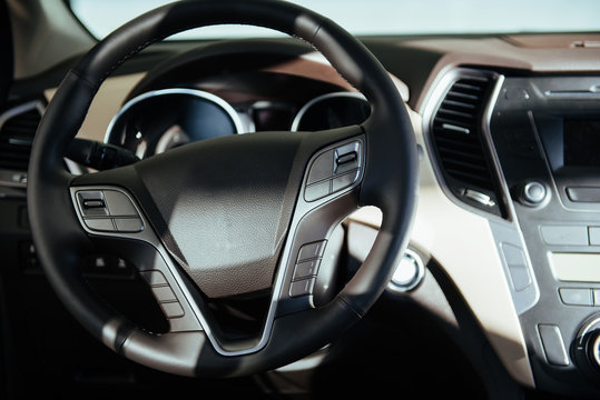 Modern car interior dashboard and steering wheel.