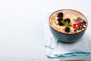 Oatmeal,Granola with Yoghurt, with Fresh berries,Blackberries,Goji berries,Chia seeds,chocolate.Healthy dry Breakfast.Diet Concept.Copy space for Text.selective focus.