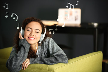 Concept of music for sleep and meditation. Young African-American woman listening to music in...