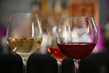 Three glasses with tasty wine on bright background, closeup