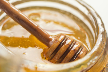 Jar of Honey with Honey stick dipper close up