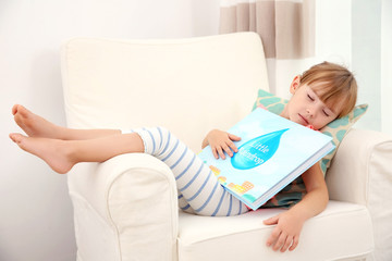 Little cute girl sleeping with book