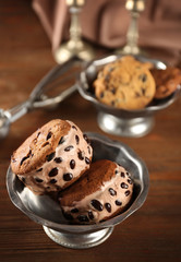 Delicious cookies with ice cream and chocolate chips in metal bowl on wooden table