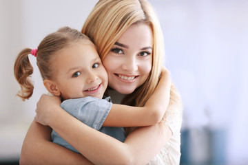 Beautiful young woman and her daughter at home. Mother's day concept