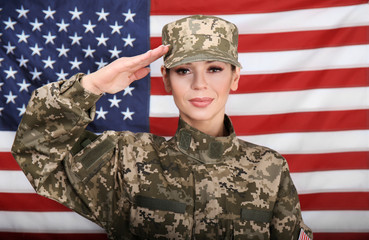 Saluting female soldier with USA flag on background