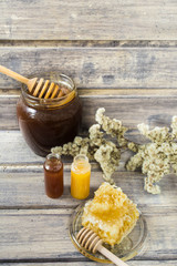 Buckwheat honey, two type of honey in the small jars and honeycomb with spoon