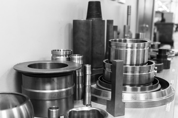 Industrial lathe tool and high precision cnc turning parts. high precision automotive machining mold and die part. CNC prosessed parts on table. Black and white