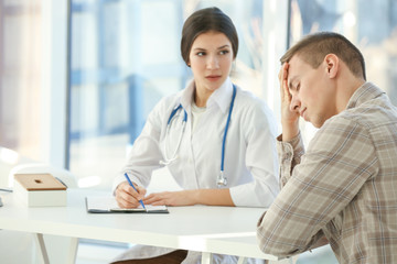 Fototapeta premium Young depressed man at doctor's office