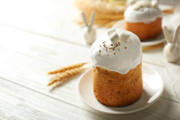 Plate with sweet Easter cake on table
