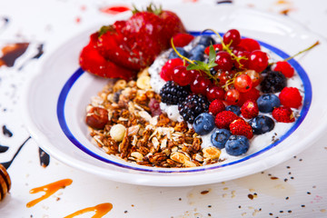 Oatmeal,Granola,Porridge with Yogurt in the  bowl.Detox. Breakfast  with  fresh berries  and nuts,honey and chia seeds.Concept of Healthy Food. selective focus.