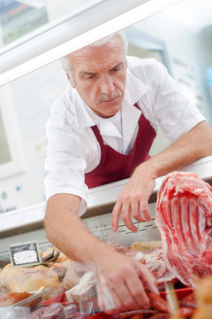Butcher getting sausages from counter