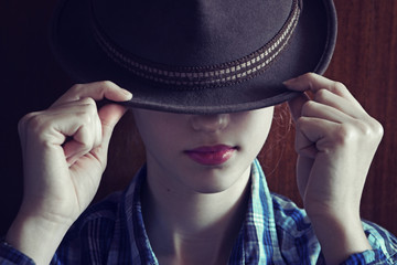 Young girl with hat. Hides her face.Depression.Photo tinted and styled with vintage photo.