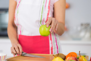 female holding green apple in hand to bale apple tart