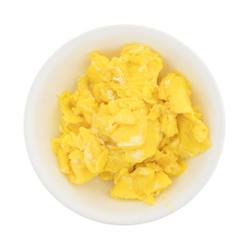 Top view of scrambled eggs in a small bowl isolated on a white background.