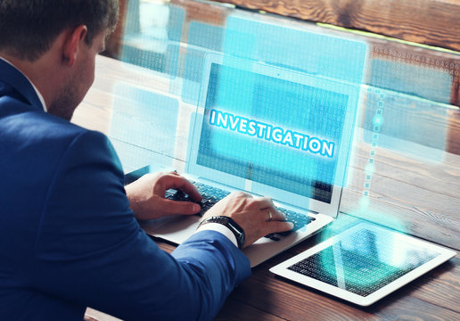Business, technology, internet and networking concept. Young businessman working on his laptop in the office, select the icon Investigation on the virtual display.