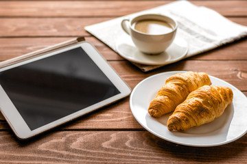 Businessman lunch at home with coffee, croisant and device