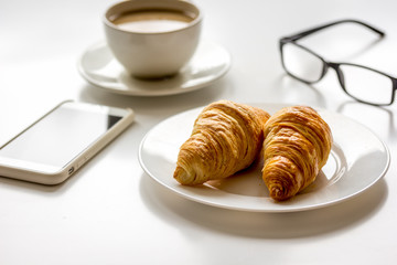 Breakfast for businessman with coffee and croissant on white table